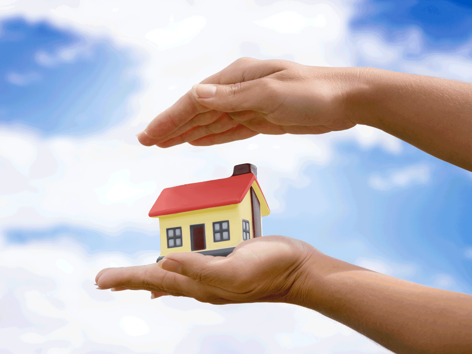 The house in hands on blue sky